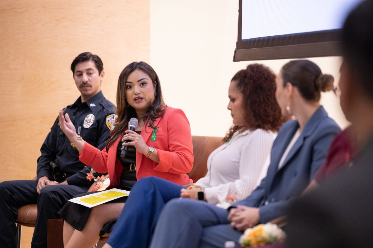 Woman on panel speaks into microphone