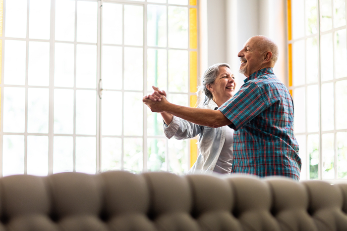 Una pareja bailando en su salón.