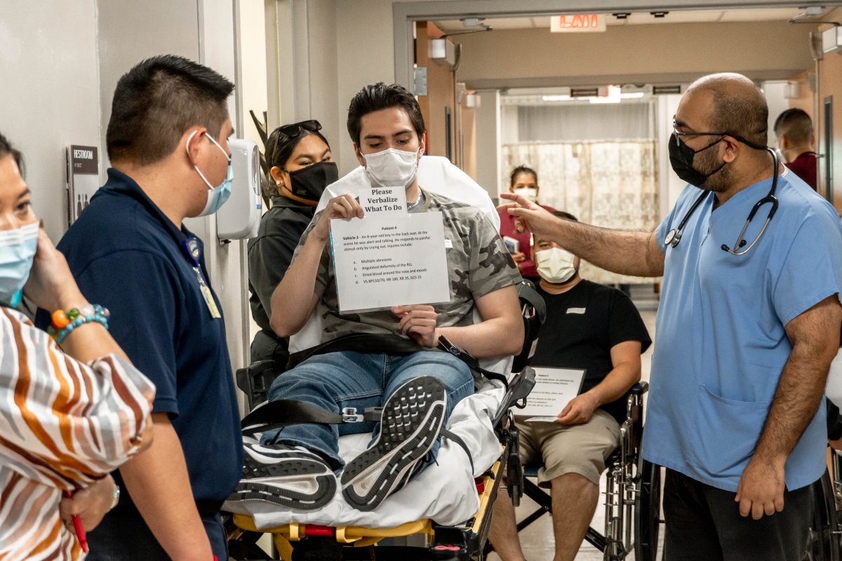 People surrounding a fake patient for an emergency drill 