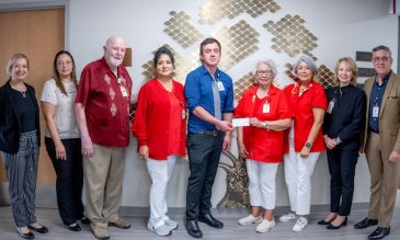 Dr. Rudy Alvarez giving a check to members of the Auxiliary to South Texas Health System