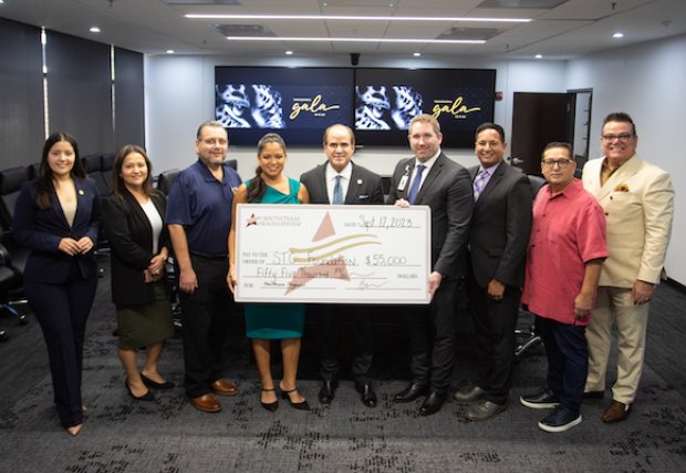 The STHS McAllen and South Texas College teams holding the large check