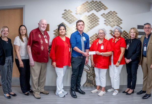 Dr. Rudy Alvarez giving a check to members of the Auxiliary to South Texas Health System