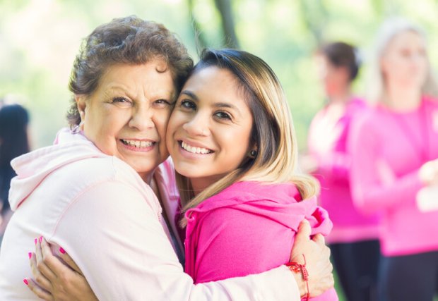two women in pink, embracing at a breast cancer event