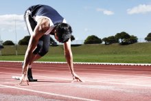 a young person poised at the track starting line