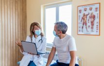 Doctor and patient wearing masks and talking