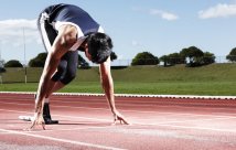 a young person poised at the track starting line
