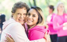 two women in pink, embracing at a breast cancer event