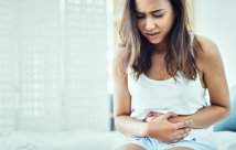 Young woman holding her stomach in pain